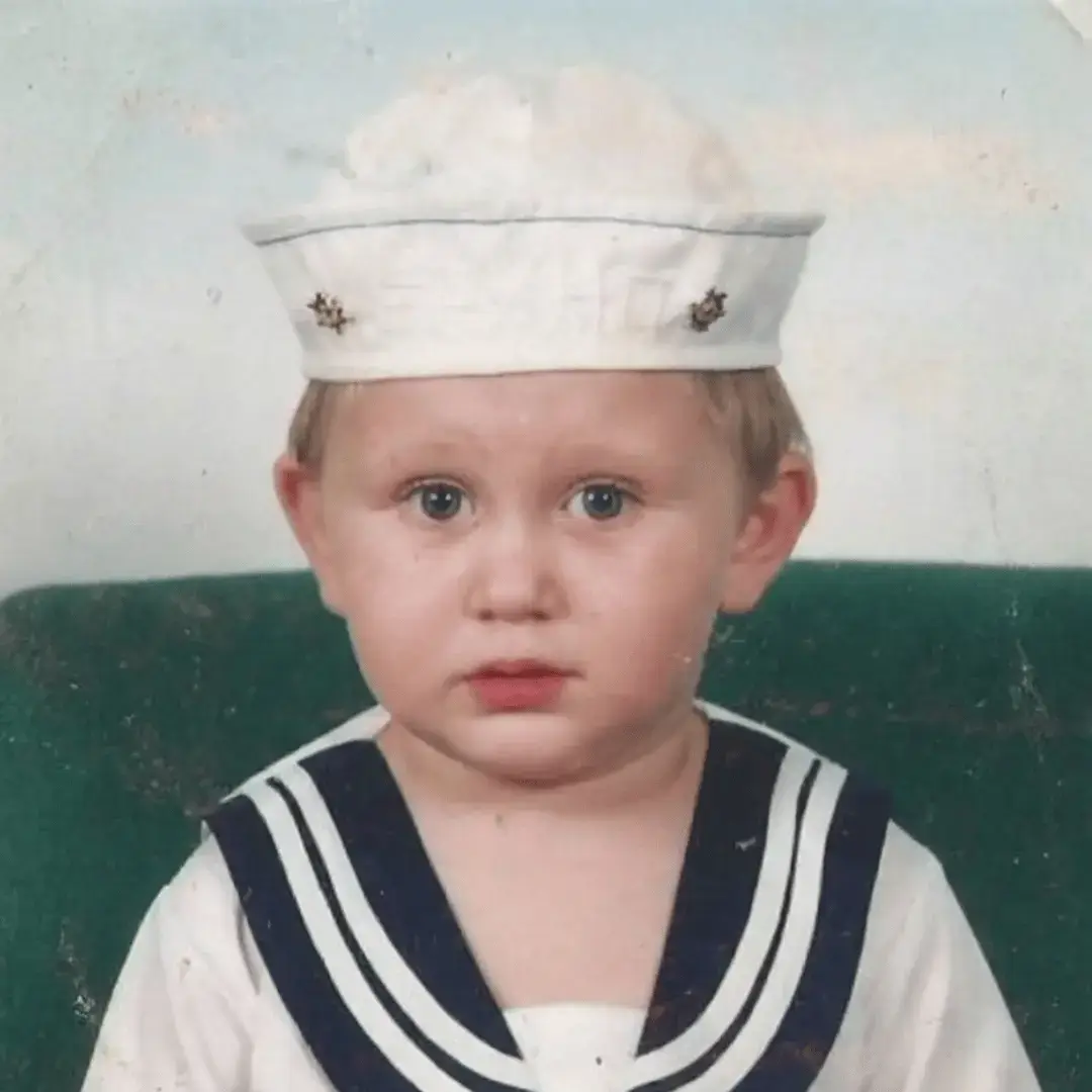 Me as a toddler in a sailor outfit with a white cap