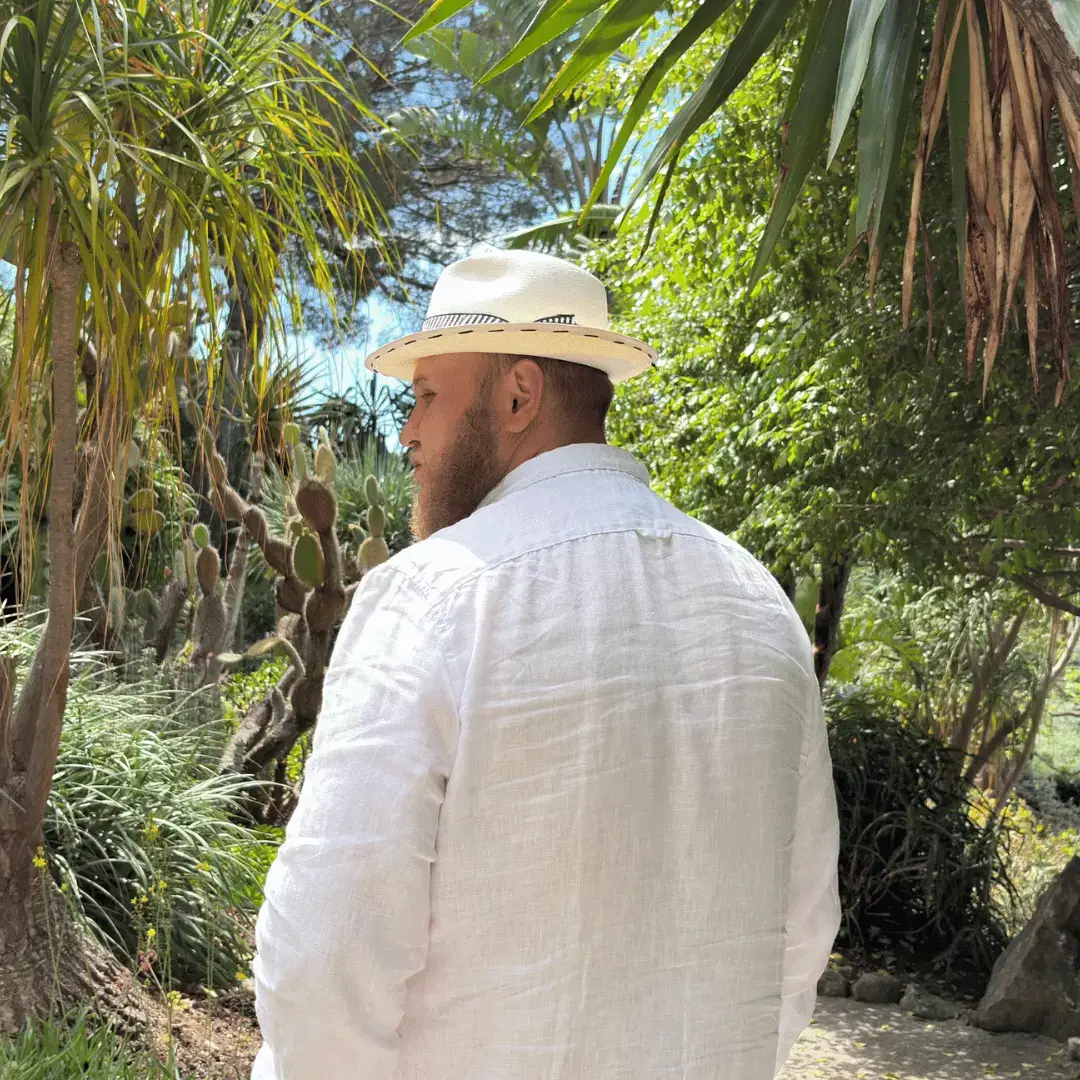Me walking outdoors from behind, wearing a straw hat and a white shirt